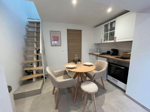 une cuisine avec une table et des chaises dans une cuisine dans l'établissement La Maisonnette, à Rouen