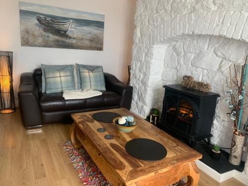 a living room with a couch and a fireplace at Beautiful Beach Front Cottage in Llandudno