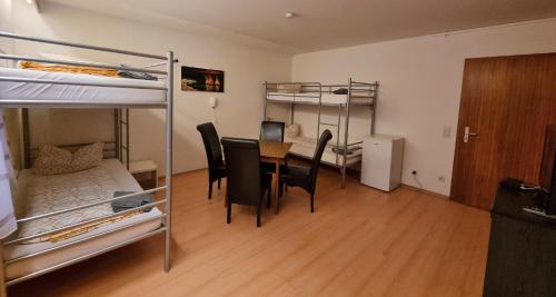 a room with a table and chairs and bunk beds at Monteurzimmer - Karlsbad in Karlsbad