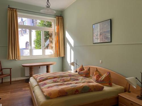 a bedroom with a bed with a window and a table at FeWo mit 2 Schlafzimmern, Wohnküche, Terrasse in Bonn
