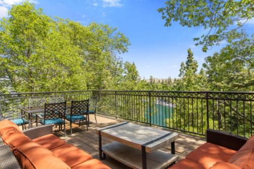 a balcony with a couch and a table and chairs at Lake Reflection Point Upscale Lake House 4 Bed and 4.5 Bath in Lake Arrowhead