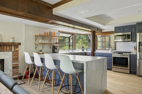 a kitchen with blue cabinets and white bar stools at Lake Reflection Point Upscale Lake House 4 Bed and 4.5 Bath in Lake Arrowhead