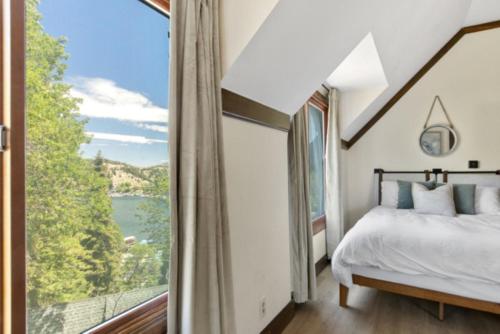 a bedroom with a bed and a large window at Lake Reflection Point Upscale Lake House 4 Bed and 4.5 Bath in Lake Arrowhead