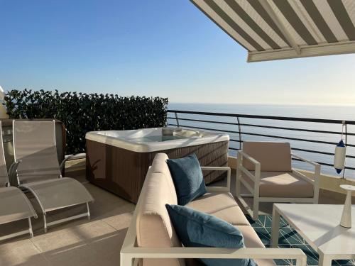 a hot tub on a balcony with chairs and tables at Sky & Sea in Sesimbra