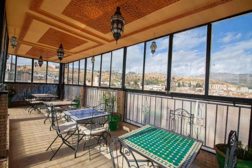 balcón con mesas y sillas y vistas a la ciudad en Riad Le Petit Patrimoine De Fés en Fez