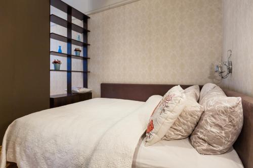 ein Schlafzimmer mit einem Bett mit weißen Laken und Kissen in der Unterkunft Central apartments 2 x Free Parking x SELF CHECK-IN 24h by H&H in Vilnius