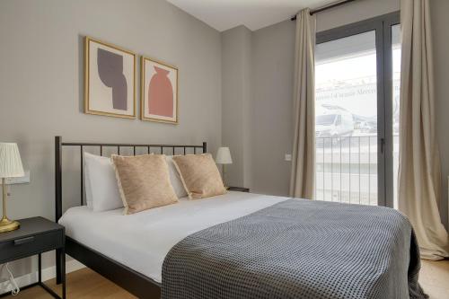 a bedroom with a bed and a large window at Blueground Poblenou pool nr Glories BCN-37 in Barcelona