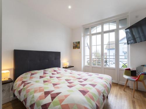 een slaapkamer met een groot bed en een groot raam bij Residence Louis Quartier Des Lilas in Vittel