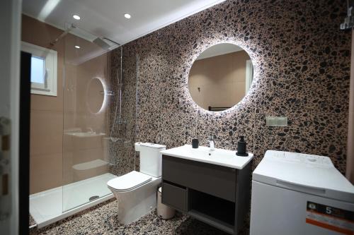 a bathroom with a toilet and a sink and a mirror at Ε121 Luxury Suites in Edessa