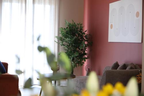 a living room with a couch and a table with a plant at Ε121 Luxury Suites in Edessa