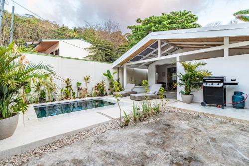 Un patio trasero con piscina y una casa. en Casa Bonimus, en Santa Teresa Beach