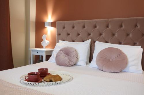 a bed with two pillows and a tray of cookies on it at Ε121 Luxury Suites in Edessa