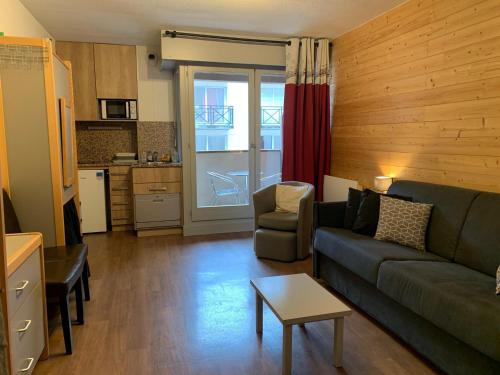 un salon avec un canapé et une table dans l'établissement Studio 4 Pers avec Balcon et Wifi au Centre de Brides-les-Bains, Proche Thermes et Remontées Mécaniques - FR-1-512-278, à Brides-les-Bains