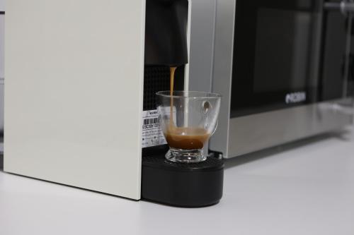 a drink is being poured into a coffee maker at Ε121 Luxury Suites in Edessa
