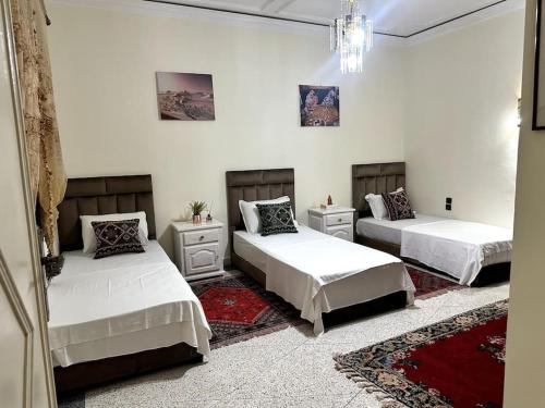 three beds in a room with white walls at Spacious fantastic closeby airport and city in Marrakesh