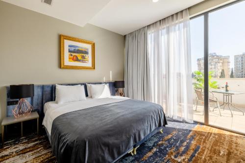 a bedroom with a bed and a large window at Brosse Garden in Tbilisi City