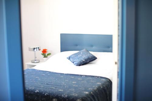 a bedroom with a white bed with a blue pillow at Maestro Damián Moderno Apartamento a Estrenar en Bilbao in Bilbao