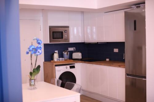 uma cozinha com armários brancos e uma máquina de lavar louça em Maestro Damián Moderno Apartamento a Estrenar en Bilbao em Bilbao