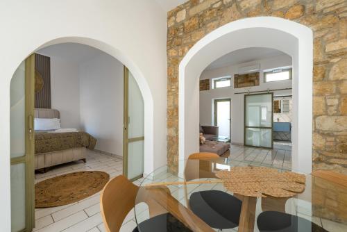 una sala de estar con una pared de piedra y una mesa. en Lefka Hotel & Apartments, en Rodas