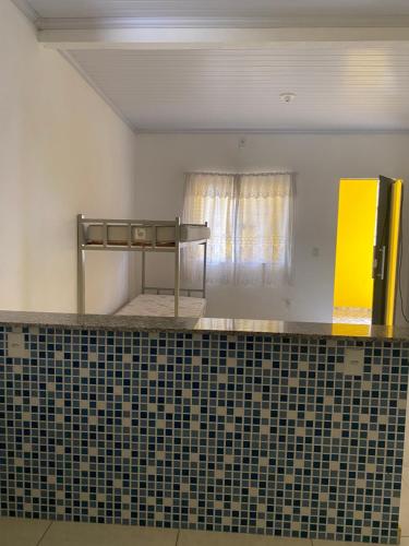 a bathroom with a tiled counter and a window at Kitnet funcional in Angra dos Reis