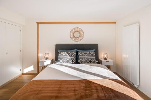 a bedroom with a large bed with two night stands at Bijou Lohnerblick - sonnig mit Terrasse&Bergsicht in Adelboden