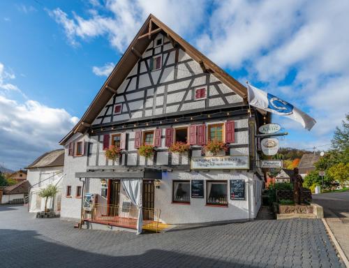 a building with red doors and windows on a street at RISA Hotel Village - Engel & Kreuz in Gaggenau