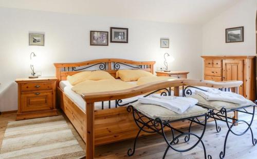 a bedroom with a wooden bed with two chairs at Chalet Alpinum in Sankt Anton am Arlberg