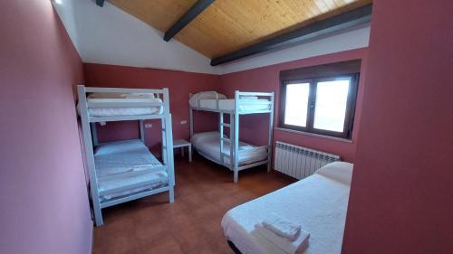 a small room with two bunk beds and a window at Albergue Villa de Salvatierra in Salvatierra de Tormes