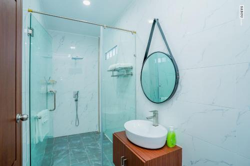 a bathroom with a shower and a sink and a mirror at Daline Private Homestay in Kampot