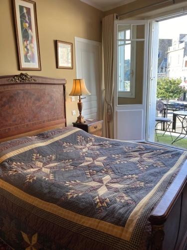 une chambre avec un grand lit et une fenêtre dans l'établissement Maison de ville, à Broons