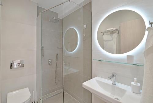 a bathroom with a shower and a sink and a mirror at Evas Rooms in Nei Poroi
