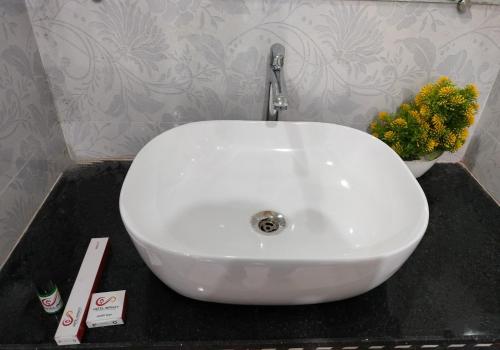 lavabo blanco en una encimera negra en el baño en Hotel Infinity, en Rajgir