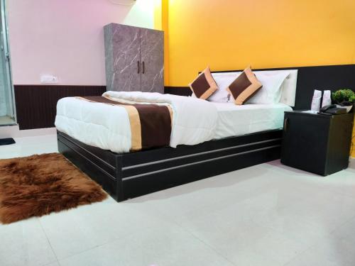 1 dormitorio con 1 cama grande con sábanas y almohadas blancas en Hotel Infinity, en Rajgir