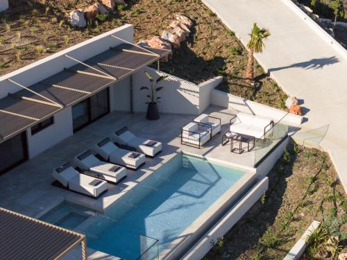 an aerial view of a house with a swimming pool at Cueva Villas, with Pool, SeaViews & close to Sea, By ThinkVilla in Balíon