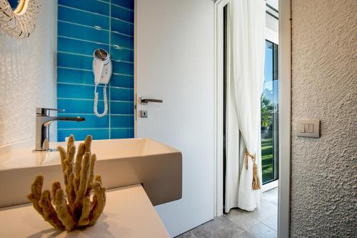 La salle de bains est pourvue d'un lavabo et d'un cactus. dans l'établissement CapoBlu Hotel, à Pula