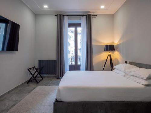 a bedroom with a white bed and a window at Moderno appartamento nel cuore di Milano in Milan