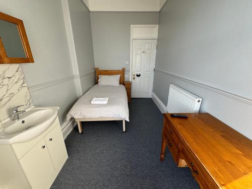 a bathroom with a sink and a bed in it at The Elms Guest House Bristol in Bristol