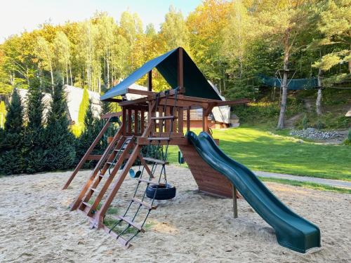 a playground with a slide in the sand at Centrum Rekreacji U Stolema in Ostrzyce