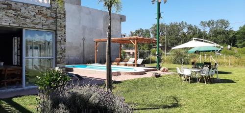 a backyard with a swimming pool and an umbrella at Quinta barrio cerrado pileta tranquilidad naturaleza in Francisco Álvarez