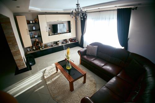 uma sala de estar com um sofá de couro e uma mesa de centro em Casa MagicPlace em Viile Satu Mare