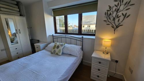 a small bedroom with a bed and a window at Trippett Cottage in Saint Breward