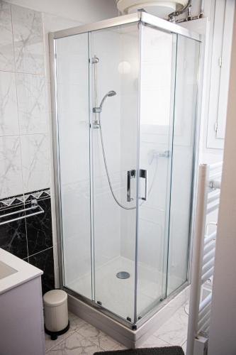 une douche avec une porte vitrée dans une salle de bain dans l'établissement Grand T1 proche Promenade des Anglais, à Nice