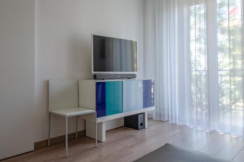 una TV seduta in cima a un supporto in una stanza di FRONTE MARE a Pesaro