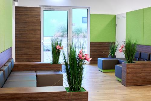 a lobby with couches and flowers in a room at Good Rooms GmbH Guntramsdorf in Guntramsdorf