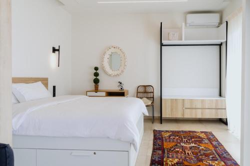 a bedroom with a white bed and a rug at Lighthouse apartments in Alexandroupoli