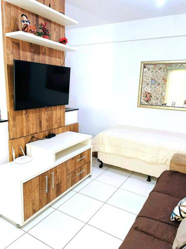 Apartamento Aconchegante Centro de Poços de Caldas في بوكوس دي كالداس: غرفة معيشة مع تلفزيون وأريكة