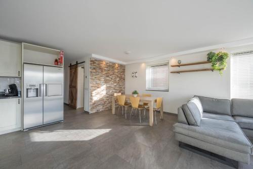 a kitchen and a living room with a couch and a table at Meerzicht 71 - Perfectly suited for 6 persons in Uitgeest