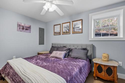 a bedroom with a purple bed and two windows at Ski Home on Bell Valley in Campton