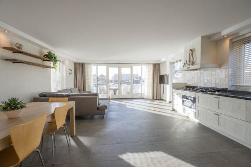 a kitchen and living room with a table and a couch at Meerzicht 71 - Perfectly suited for 6 persons in Uitgeest
