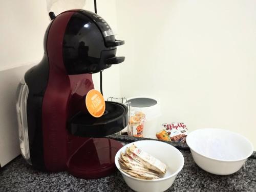 a coffee maker sitting on a counter next to a bowl at Queen's Flats in Brasilia